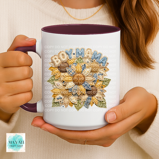 Person holding a mug with 'BOY MAMA' design featuring sunflowers.