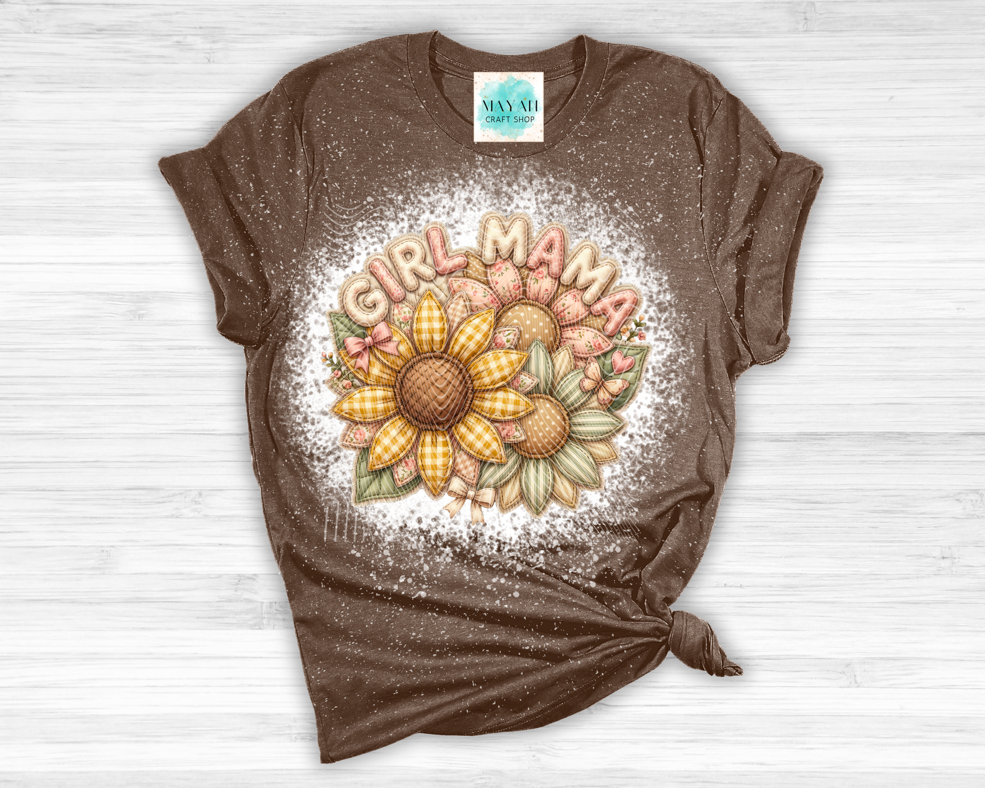 Brown t-shirt with sunflower design and 'Girl Mama' text on a white wooden surface