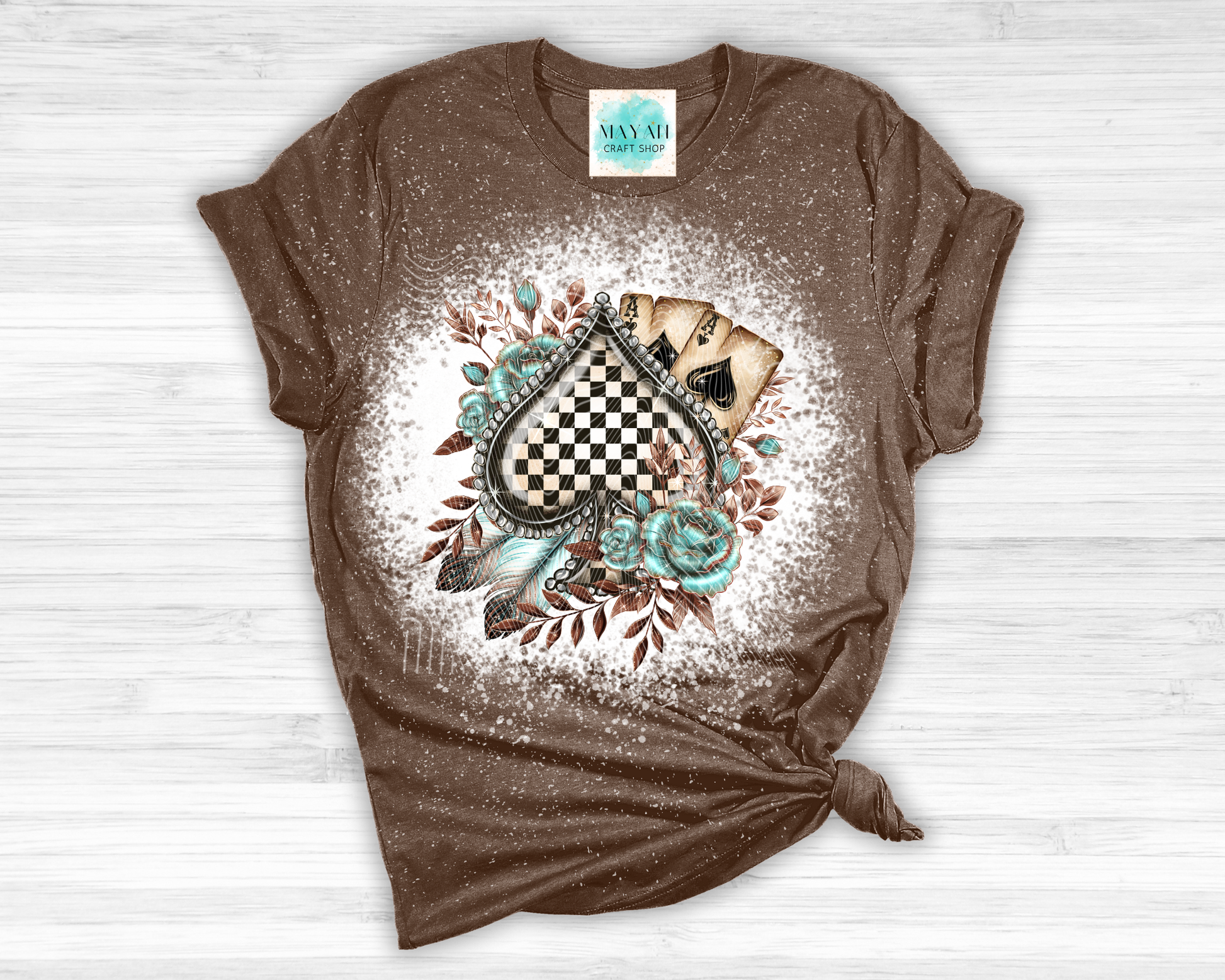 Brown t-shirt with a decorative design on a white wooden surface