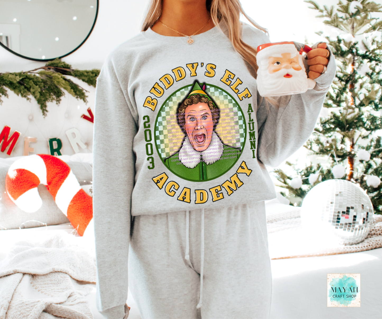 Person wearing a sweatshirt with 'Academy' graphic, holding a mug in a festive setting.