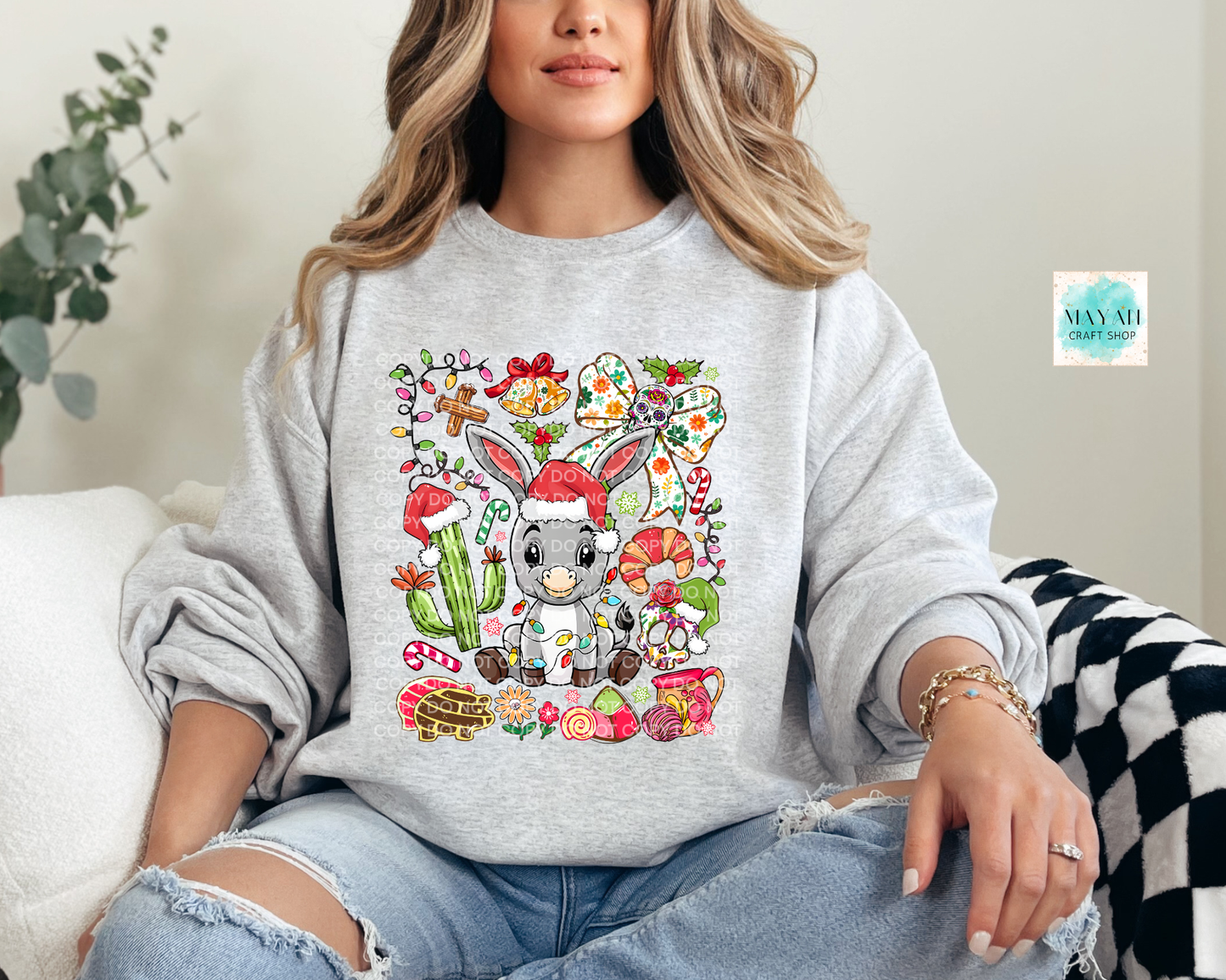 Person wearing a gray sweatshirt with a colorful donkey design, sitting on a couch.