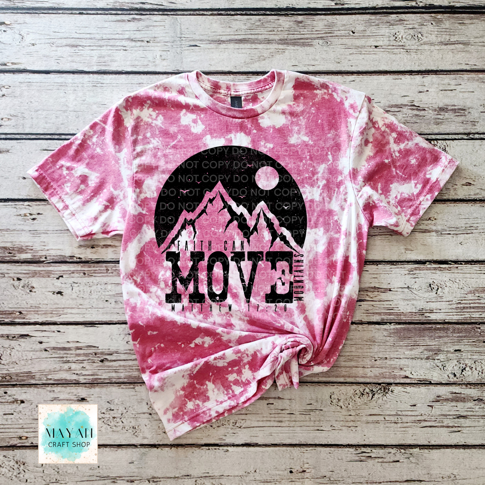 Pink tie-dye t-shirt with mountain graphic and 'MOVE' text on a wooden surface