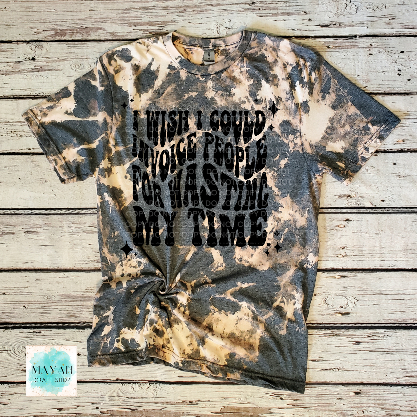 Bleached t-shirt with text on a wooden surface, featuring the brand 'Mayan Craft Shop'.