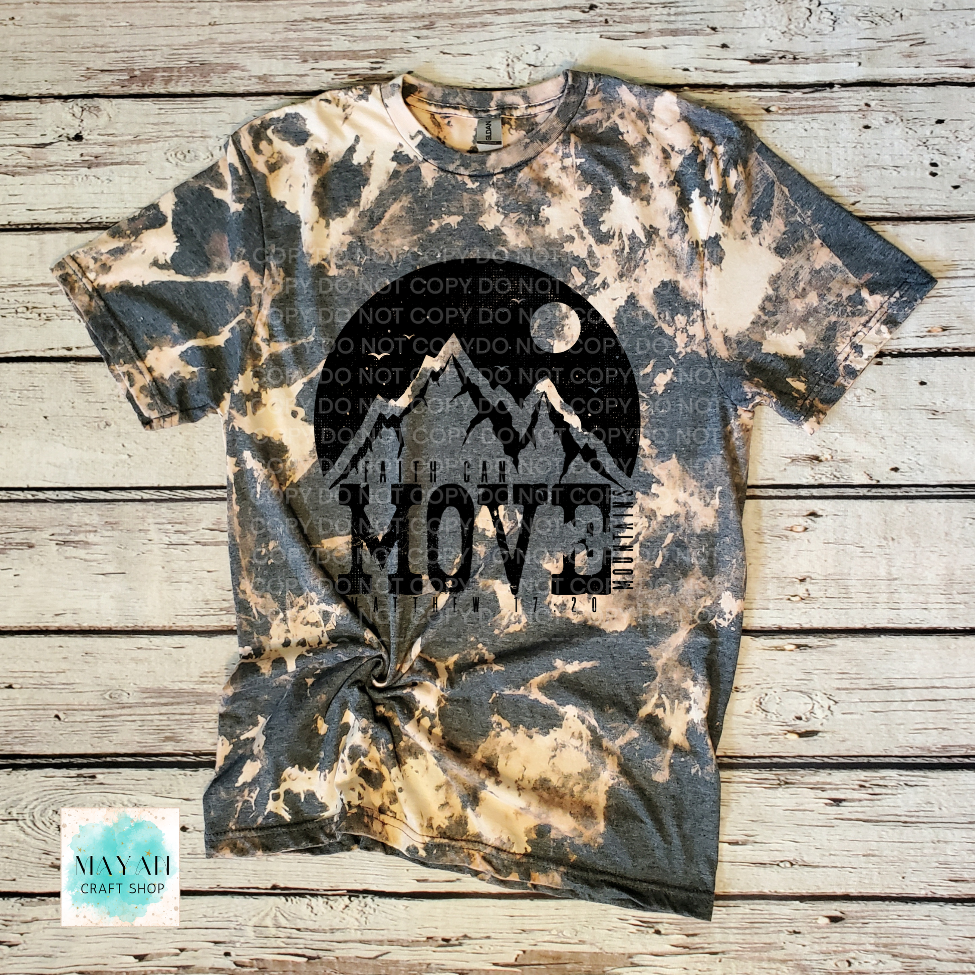 Tie-dye t-shirt with mountain graphic and 'Move' text on a wooden surface