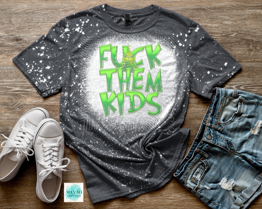 Gray t-shirt with green text, white sneakers, and jeans on a wooden surface