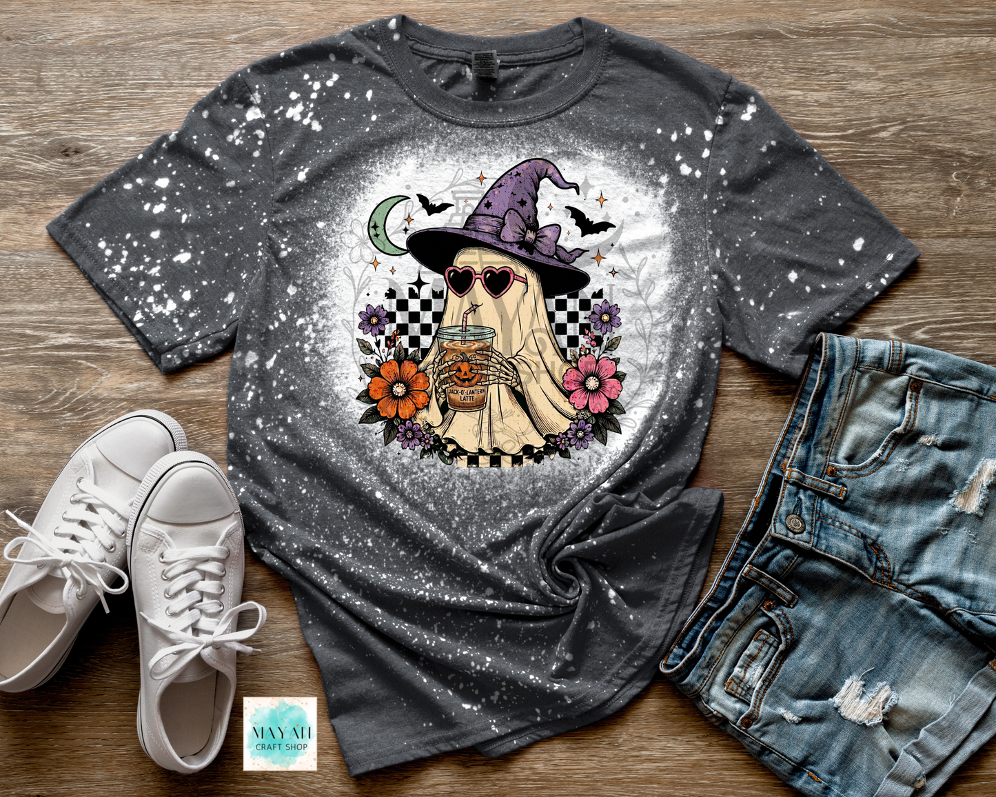 Gray t-shirt with a ghost graphic, white sneakers, and denim shorts on a wooden surface.