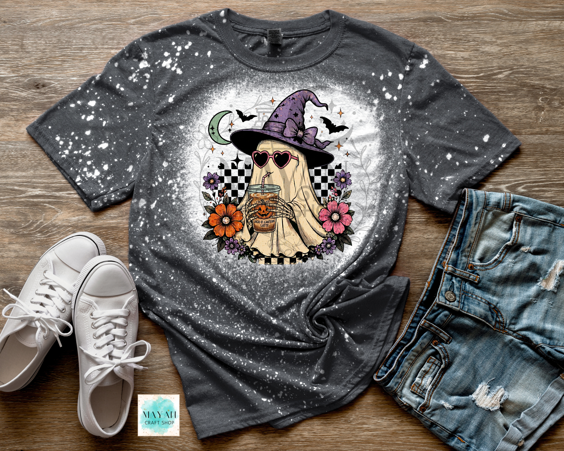 Gray t-shirt with a ghost graphic, white sneakers, and denim shorts on a wooden surface.