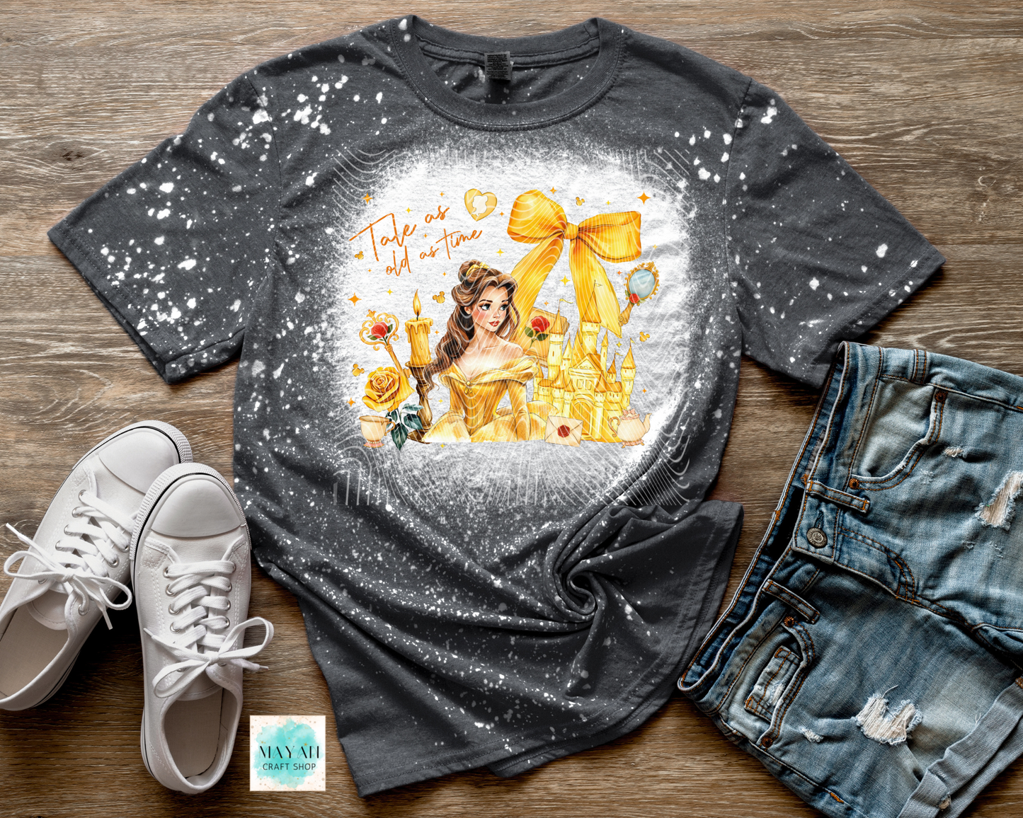 Gray t-shirt with princess graphic, white sneakers, and denim shorts on a wooden surface.