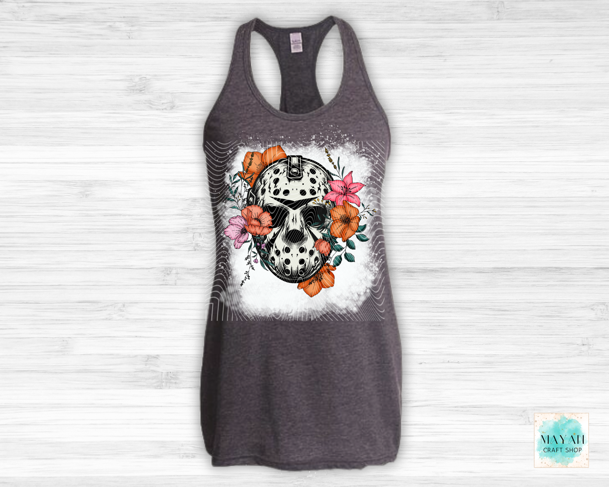 Gray tank top with a skull and floral design on a white wooden background