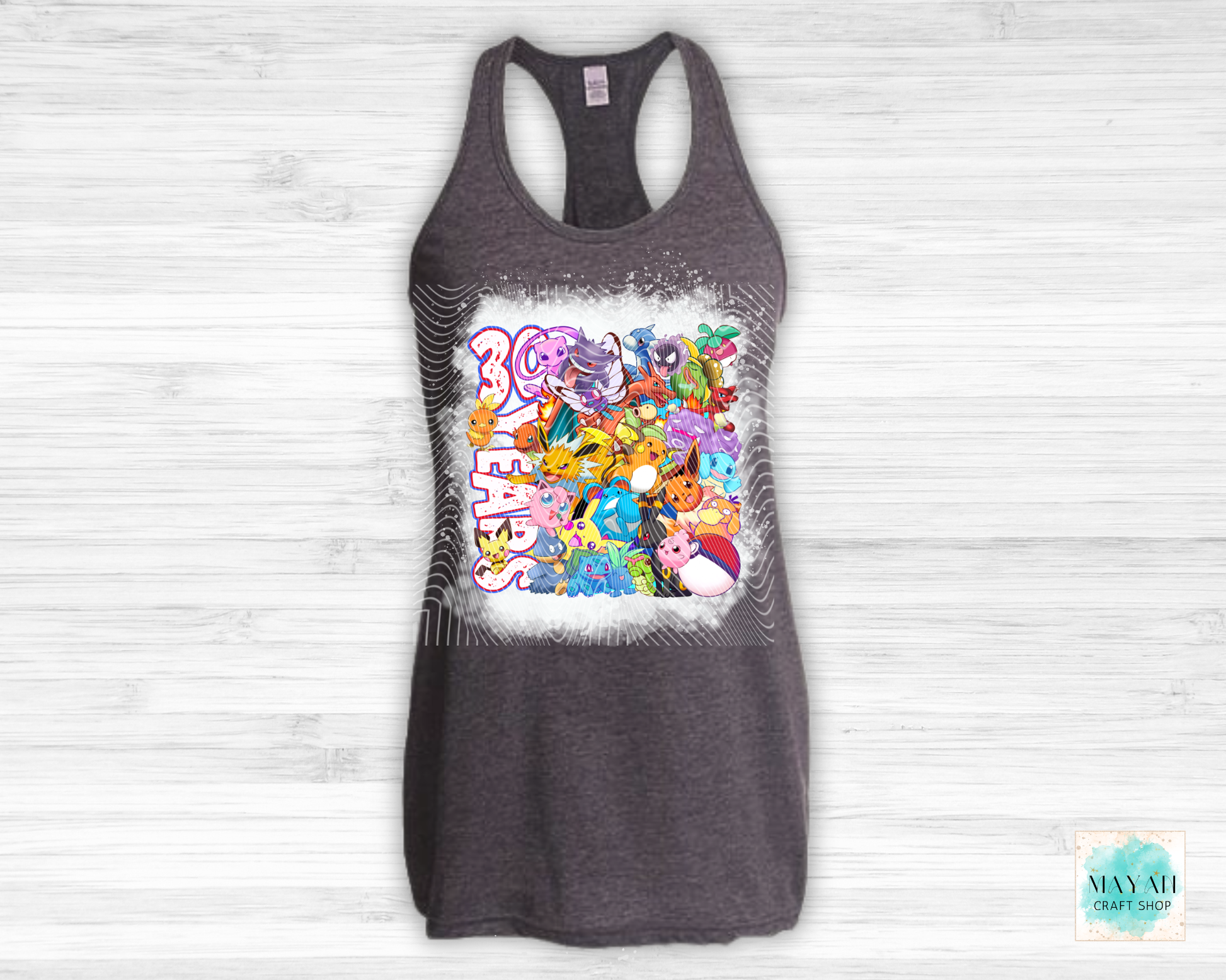 Gray tank top with colorful graphic design on a white wooden background
