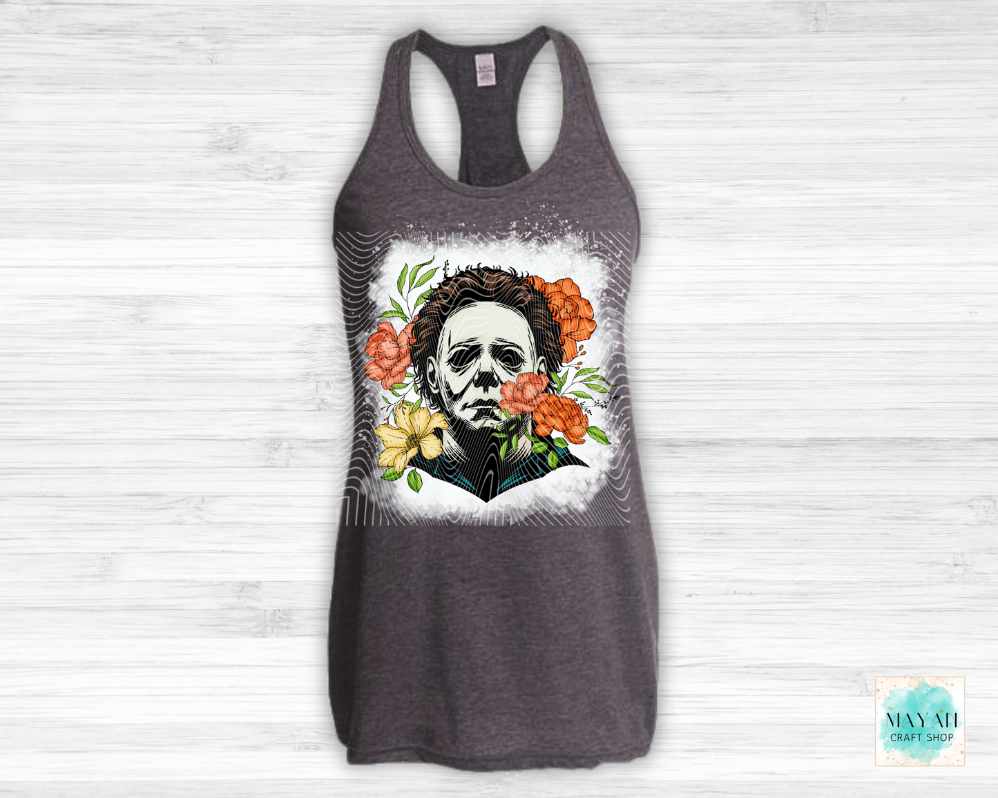 Gray tank top with a graphic design of a face surrounded by flowers on a white background