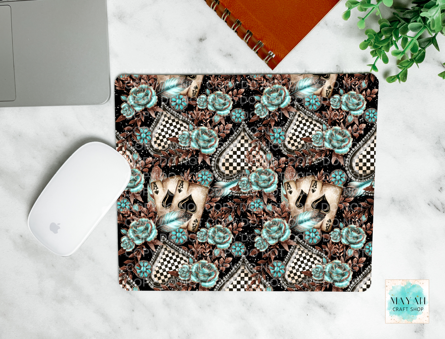 Mouse pad with a decorative case featuring roses and checkered patterns on a marble surface.