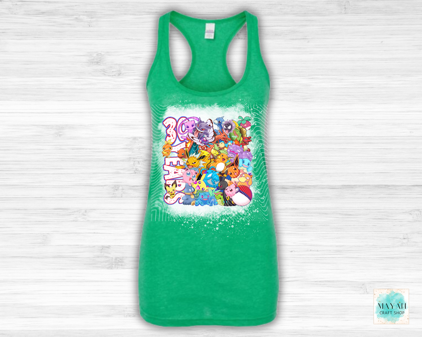 Green tank top with colorful graphic design on a light wooden background