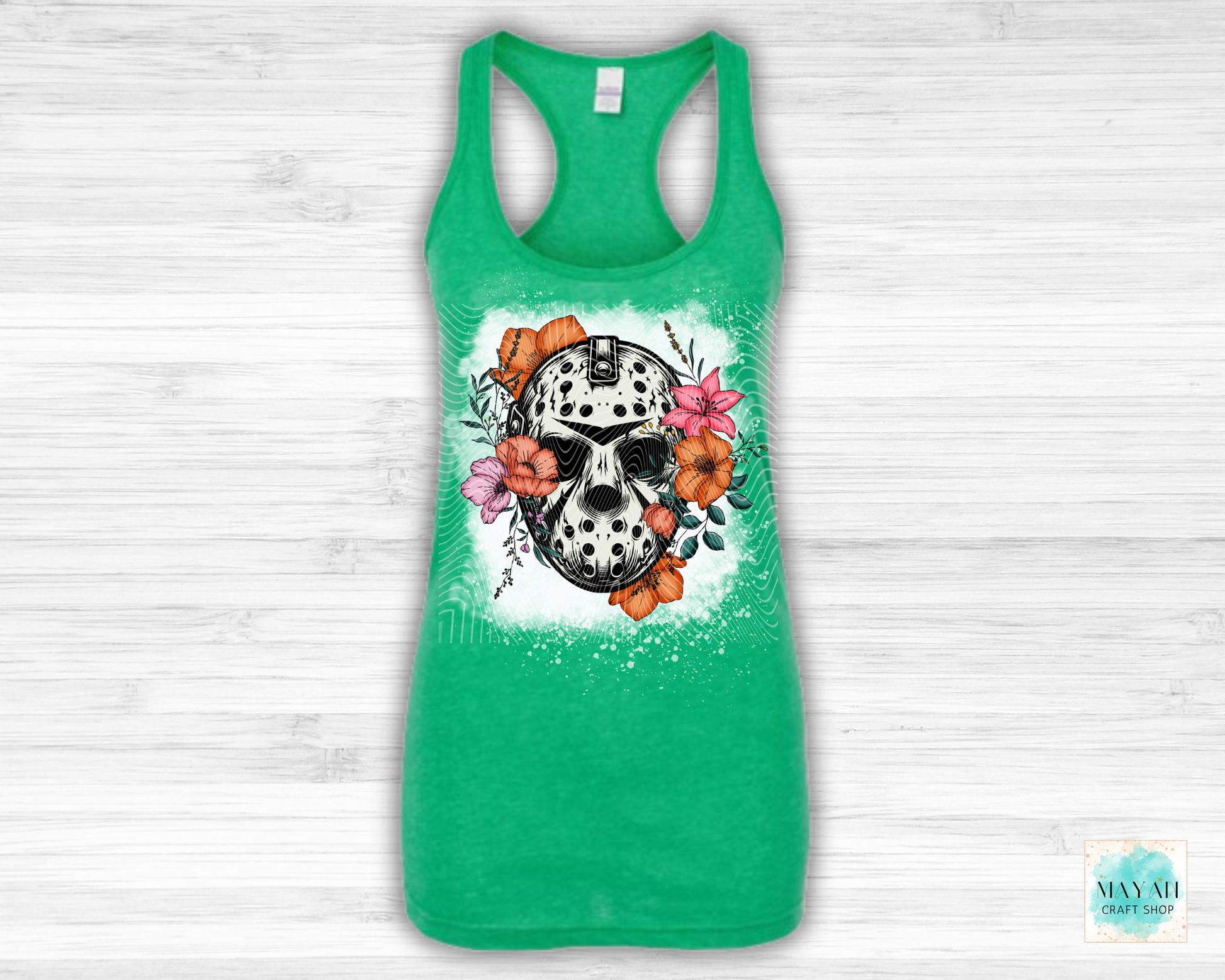Green tank top with a skull and flowers design on a white wooden background