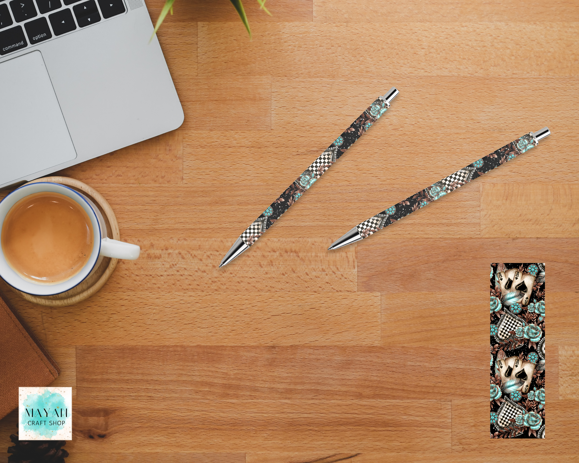 Two patterned pens on a wooden desk with a laptop and coffee cup.