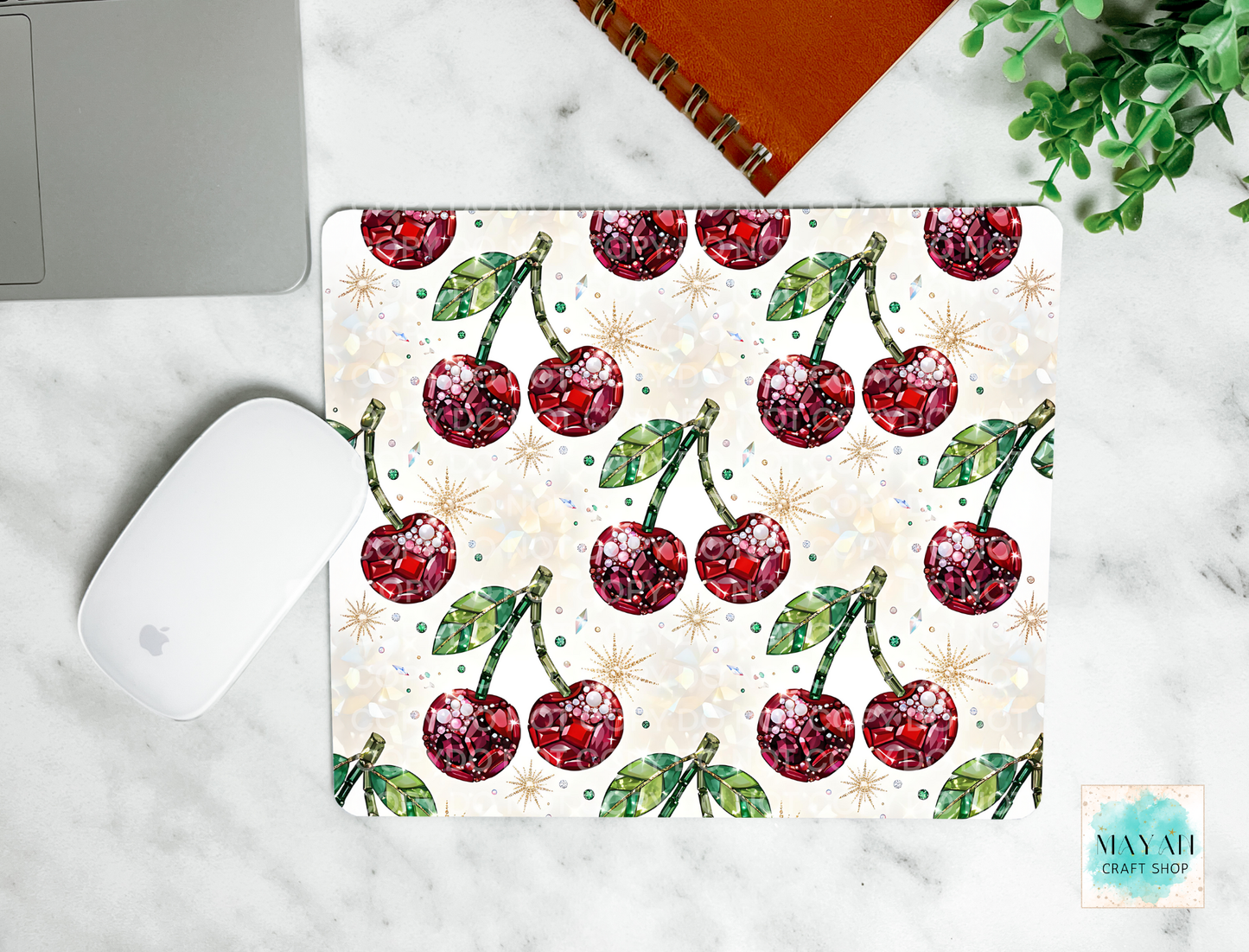 Cherry patterned mouse pad on a marble surface with a laptop and mouse.