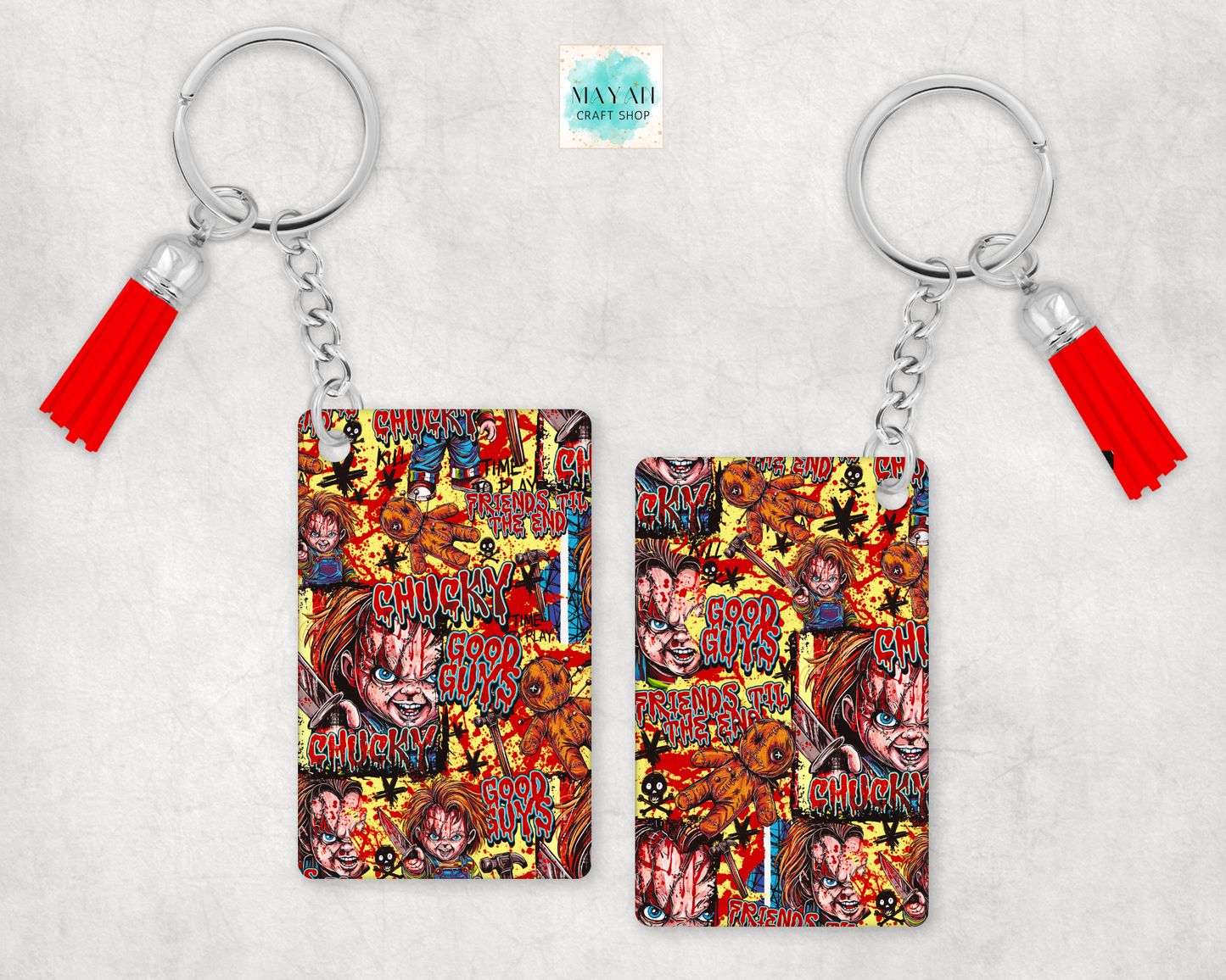 Two keychains with red tassels, featuring a colorful collage print of Chucky's character art and words on a light gray textured background.
