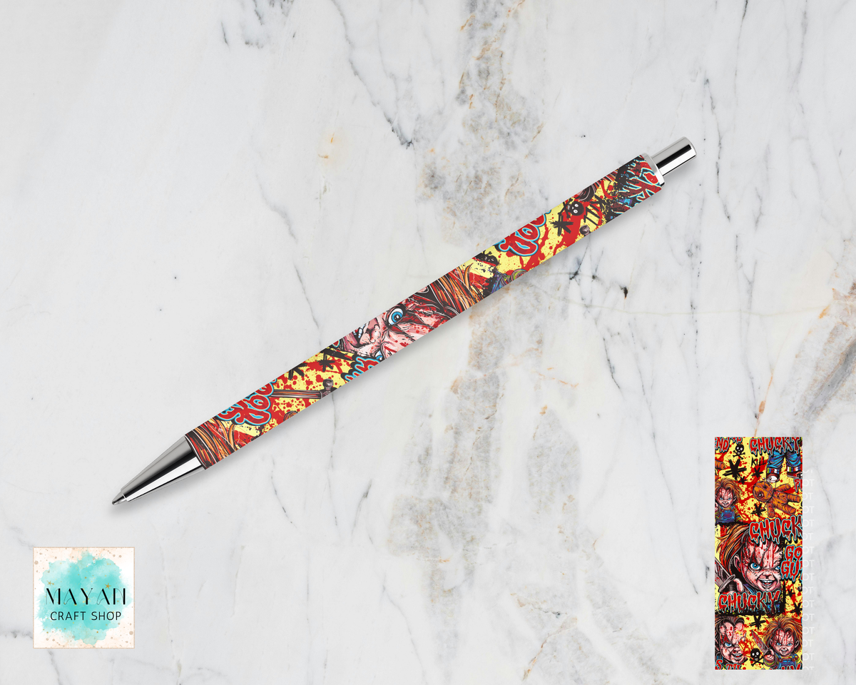 A ballpoint pen with a colorful, detailed illustration pattern on its barrel, displayed diagonally on a white marble background. A close-up of the pattern is shown in a small vertical frame on the bottom-right.