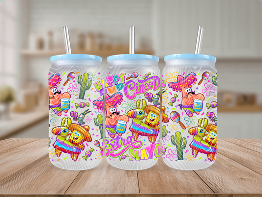 Three colorful tumblers with festive designs on a wooden surface.