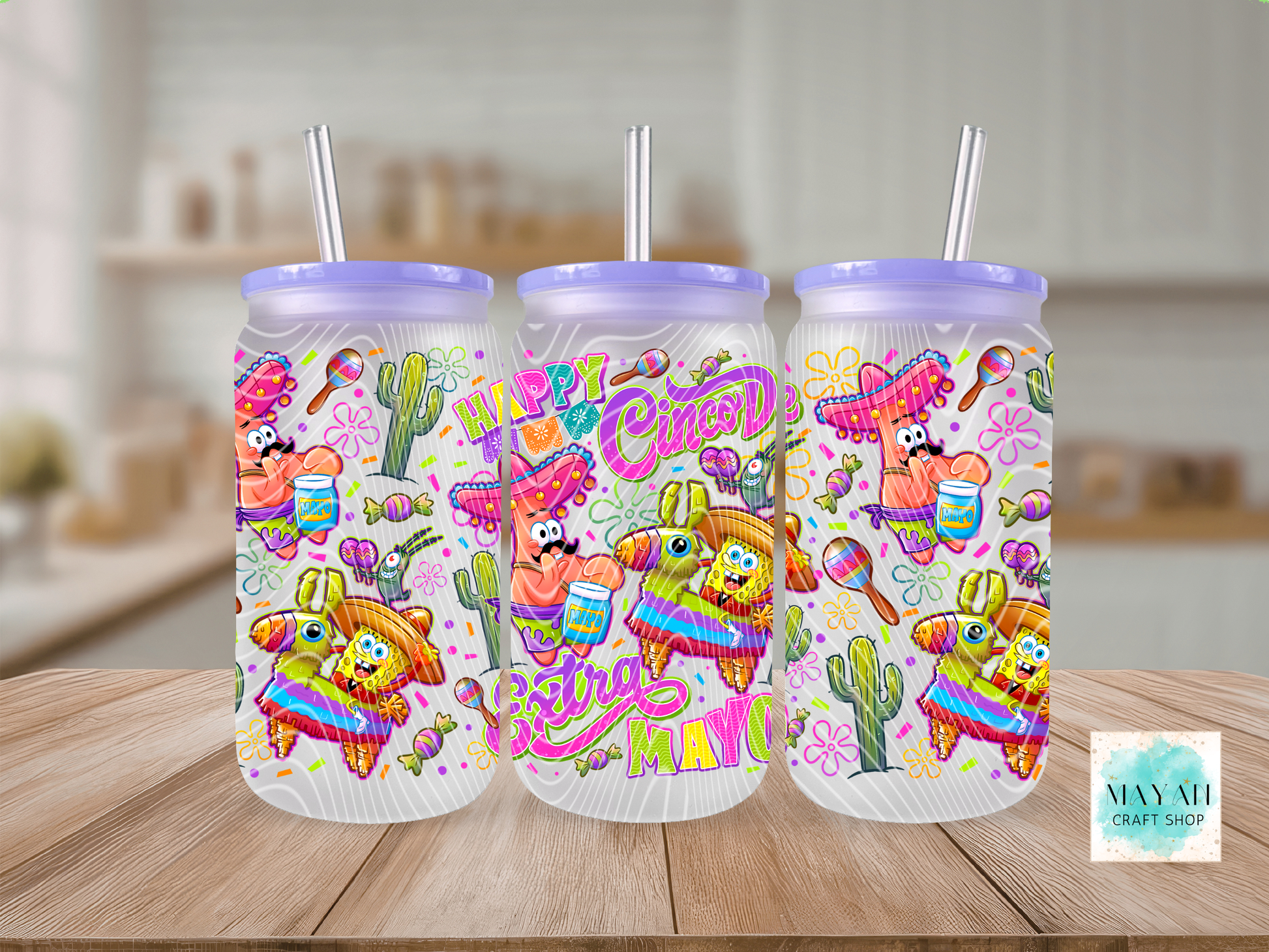 Three colorful tumblers with festive designs on a wooden surface.