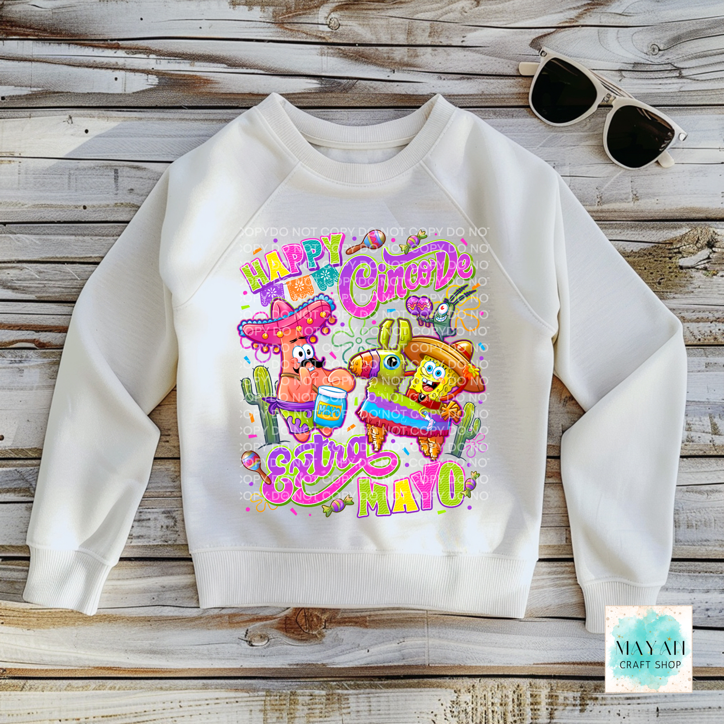 White sweatshirt with colorful graphic design on a wooden surface