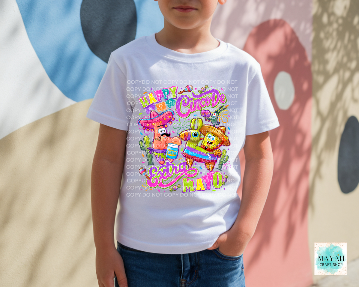 Child wearing a white t-shirt with colorful graphics and text against a multicolored background