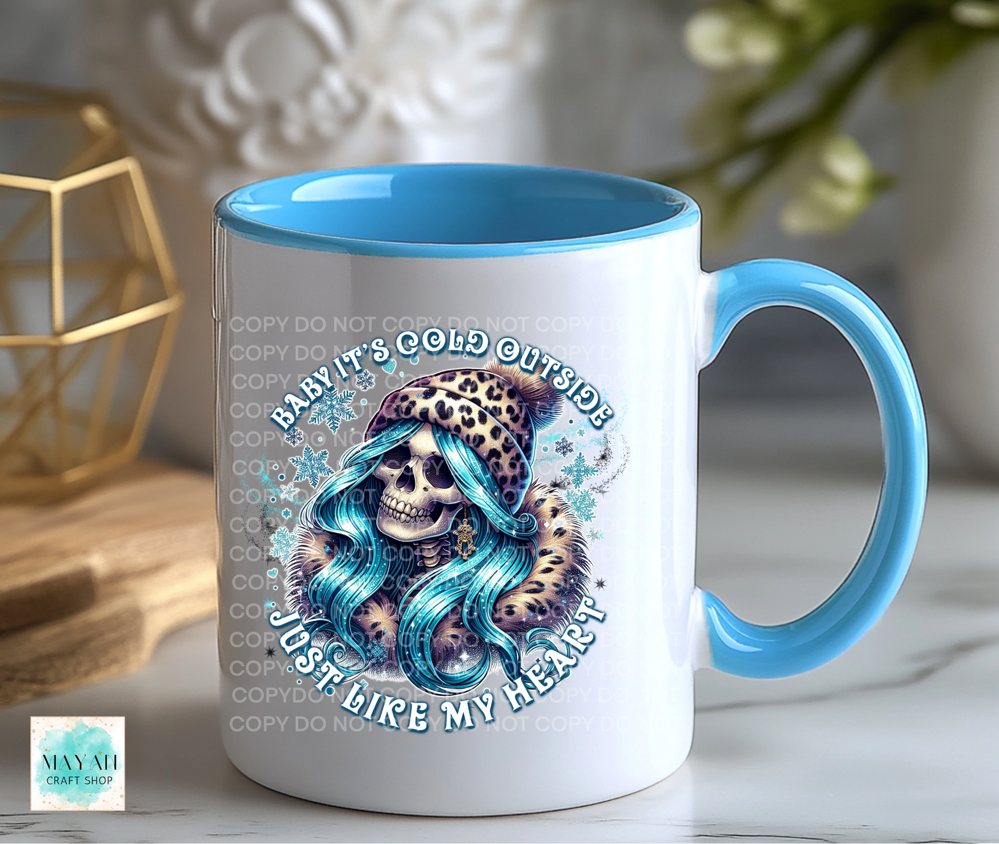 Mug with skull and leopard design, text 'Brrit's cold outside, just like my heart', blue interior and handle.