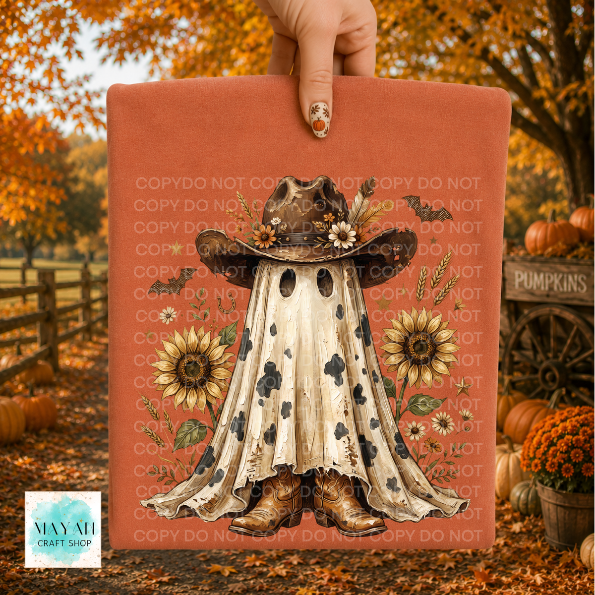 A hand holds a shirt with a fall-themed ghost in a cowboy hat design, set against an autumn outdoor background with pumpkins, fall leaves, and a wooden fence. The sign has a terracotta background with a central illustration of a ghostly figure in a cowboy outfit, surrounded by sunflowers and small wildflowers.