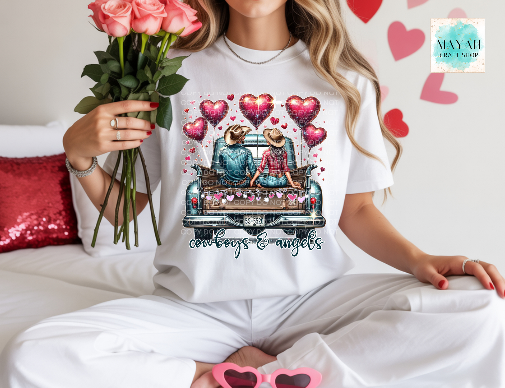 Person wearing a white t-shirt with a graphic design of a couple in a car surrounded by hearts, holding flowers.