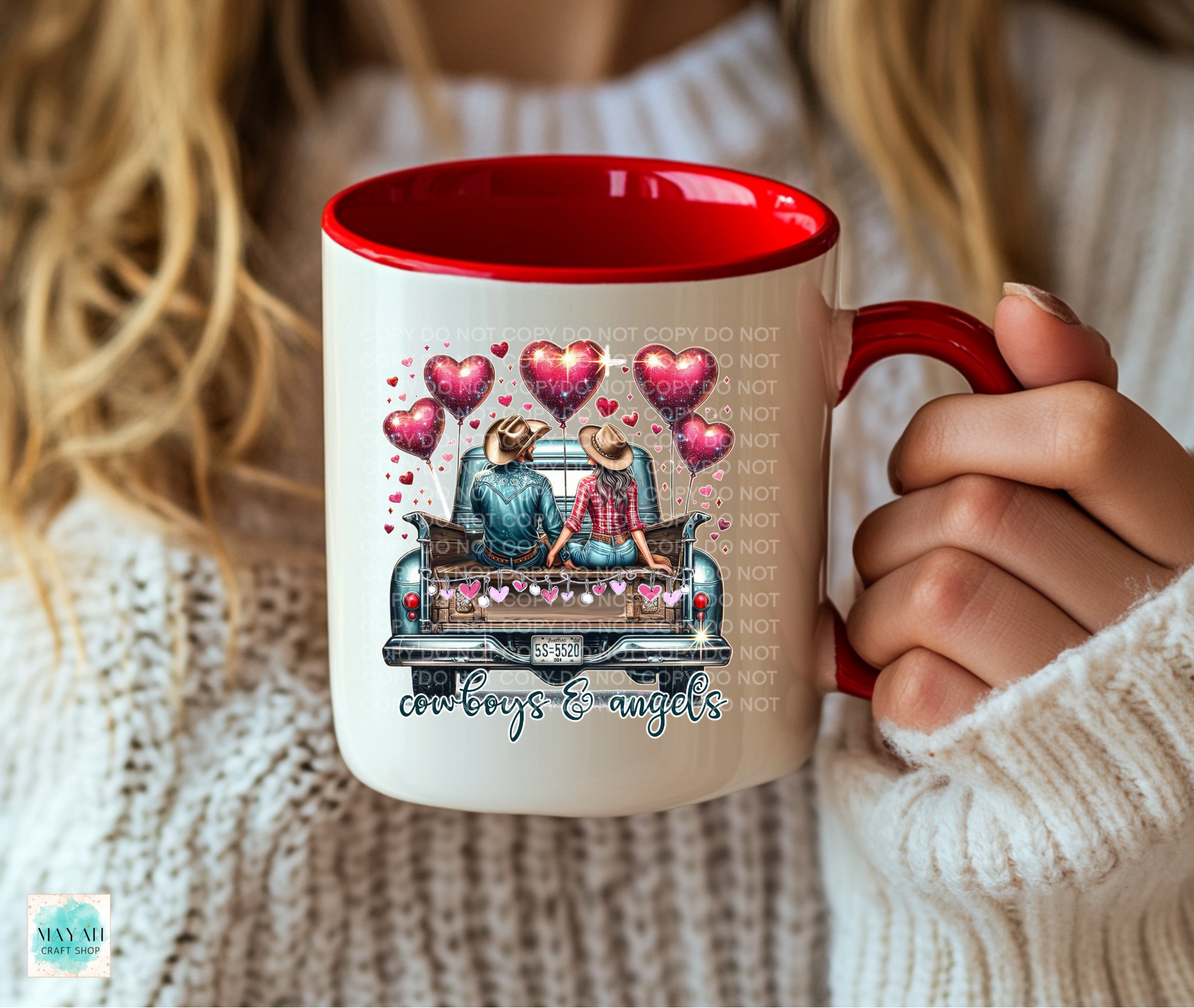 Person holding a mug with a design of cowboys and angels, surrounded by hearts.