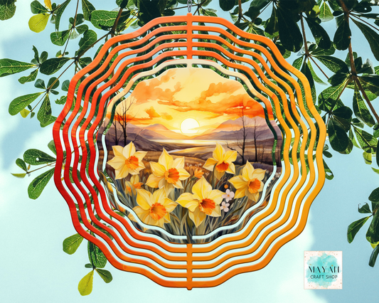 Decorative plate with a sunset and flower design, surrounded by green leaves.