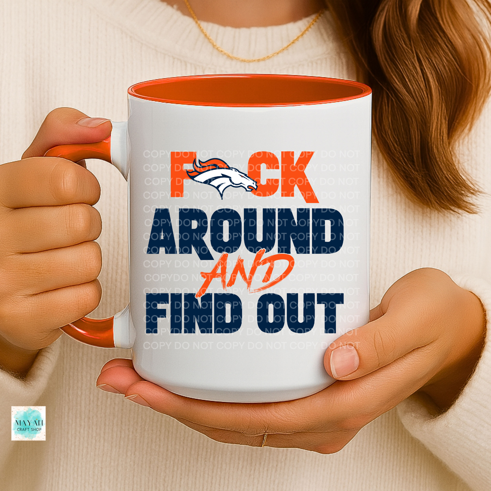 Person holding a mug with a colorful design and text.