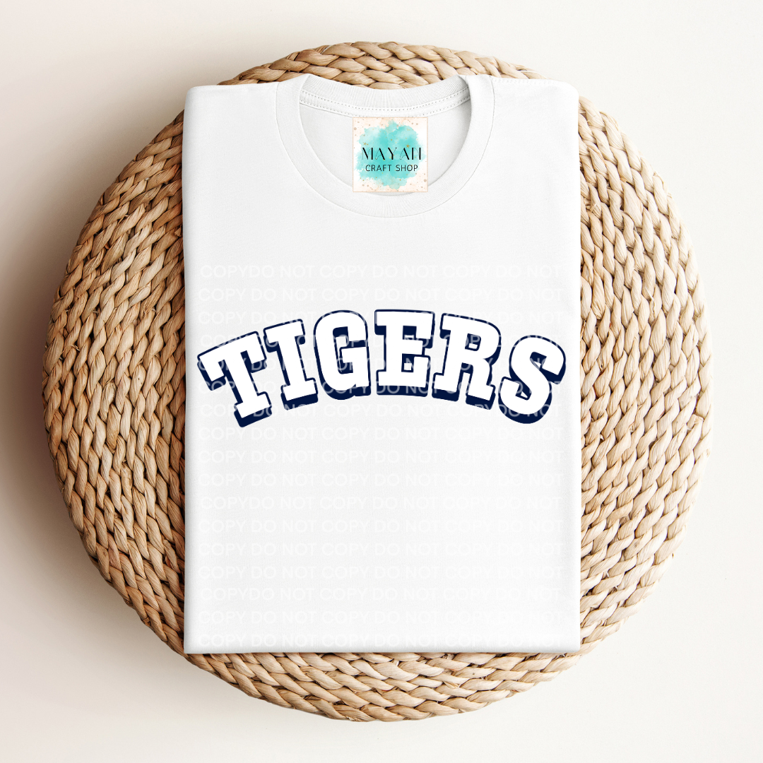 White t-shirt with a baseball logo printed on it, displayed on a woven mat.