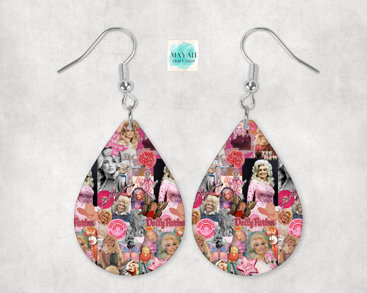 A pair of teardrop-shaped dangle earrings with silver fishhook wires, featuring a colorful collage print with pink, red, black, and white images and text.