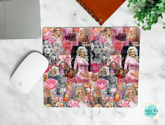 A square mouse pad with a vintage collage print of a country singer, featuring pink roses, black-and-white portraits, and pink text, shown on a white marble desk flat-lay with a white mouse, a laptop corner, an orange notebook, and a green plant.