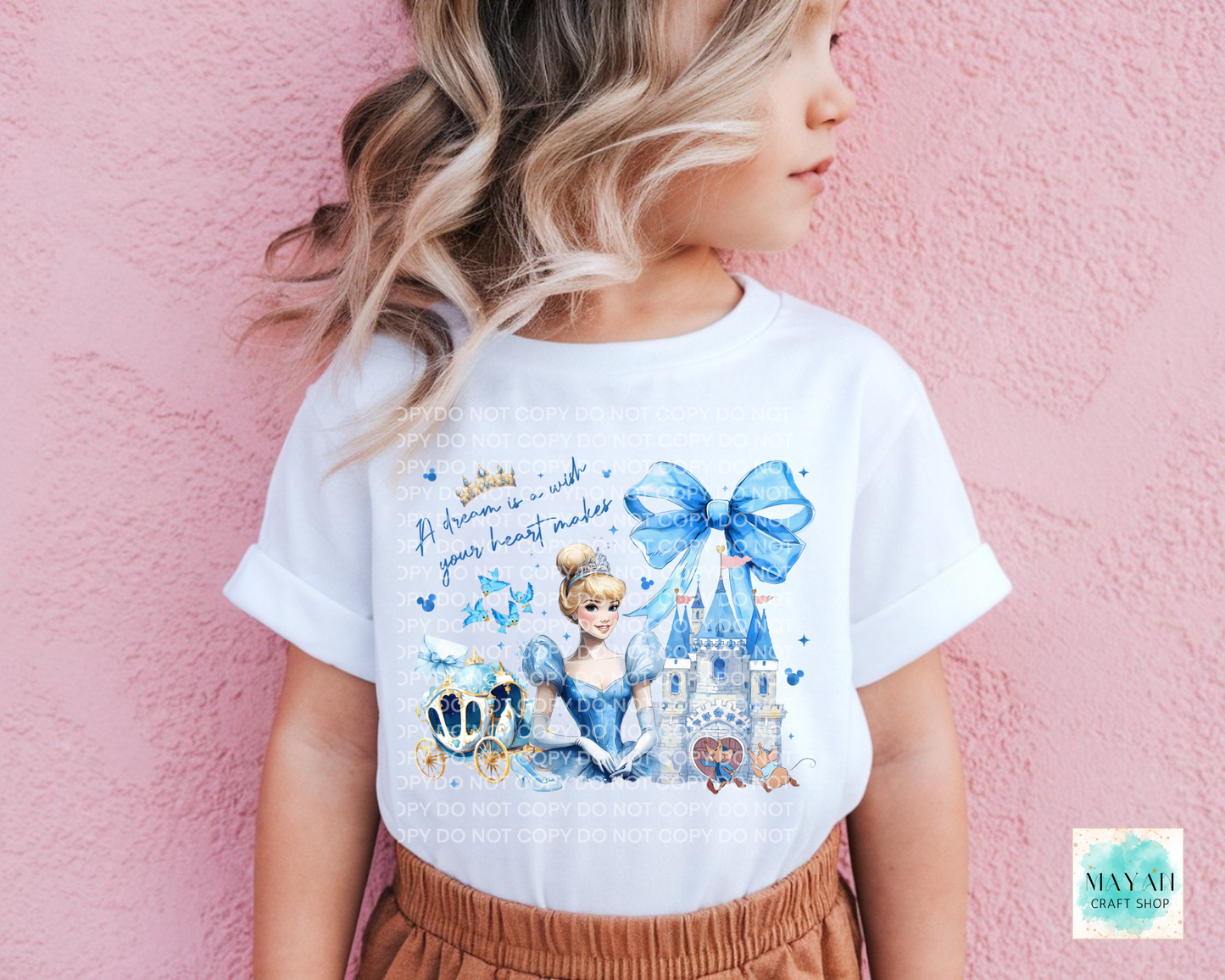 Child wearing a white t-shirt with a princess design against a pink background