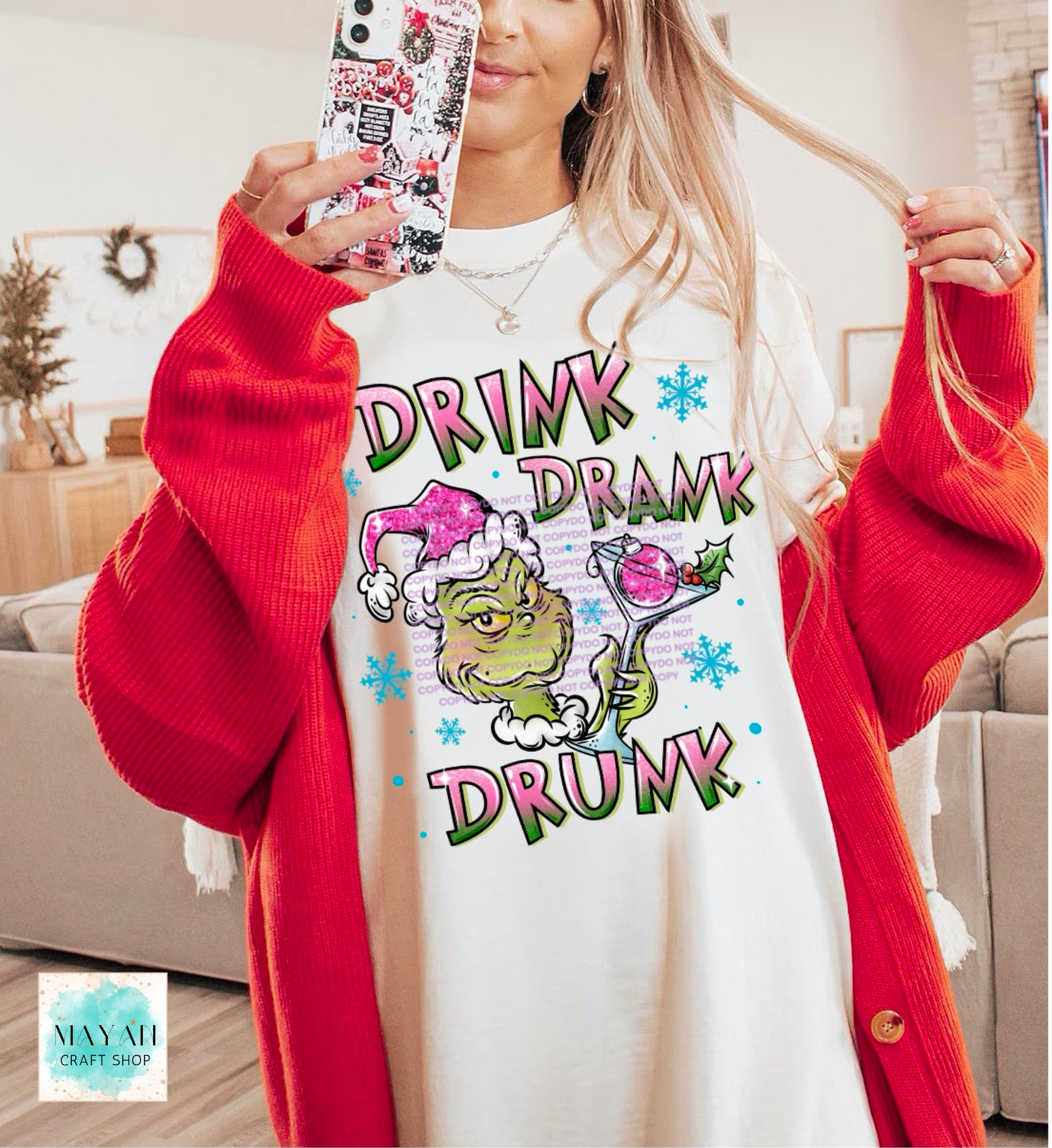 Person wearing a white sweatshirt with a colorful graphic and text, holding a phone with a decorated case.