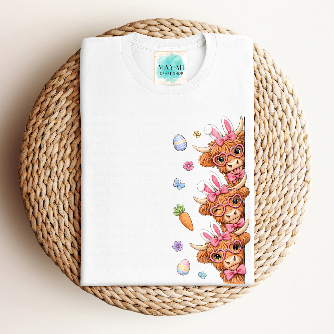 White t-shirt with cartoon cow design on a woven mat