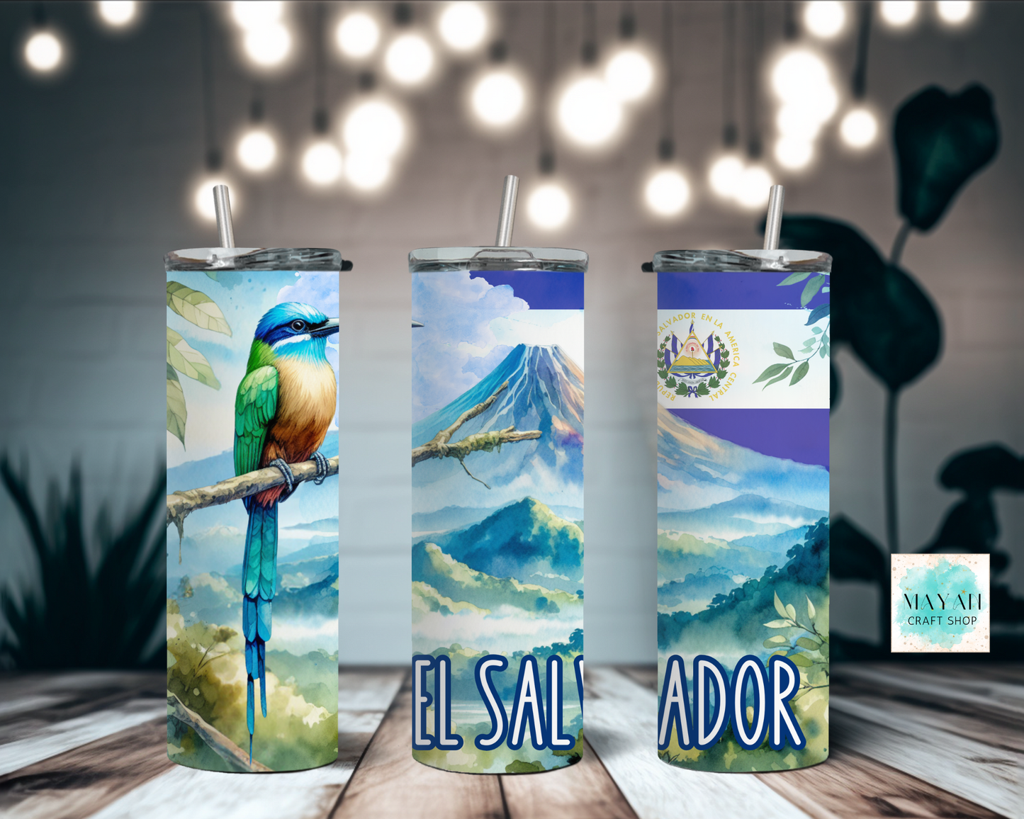 Three tumblers with scenic designs and 'El Salvador' text on a wooden surface.