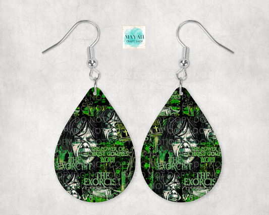 A pair of teardrop-shaped dangle earrings with silver fishhook wires, featuring a green and black graphic print of a face and a text.