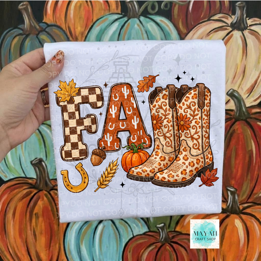 A hand holds a white t-shirt featuring a western-themed 'FALL' graphic with autumn and cowboy boot illustrations, set against a painted background of pumpkins. 