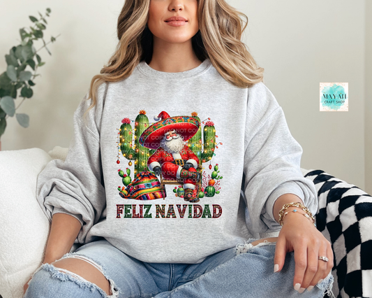 Person wearing a gray sweatshirt with a festive design and 'Feliz Navidad' text.