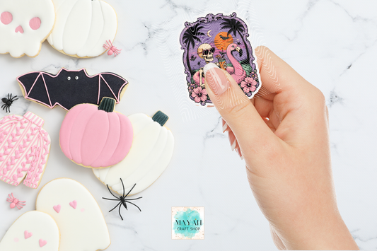 Decorative Halloween cookie cutters with a hand holding sticker, on a marble surface.