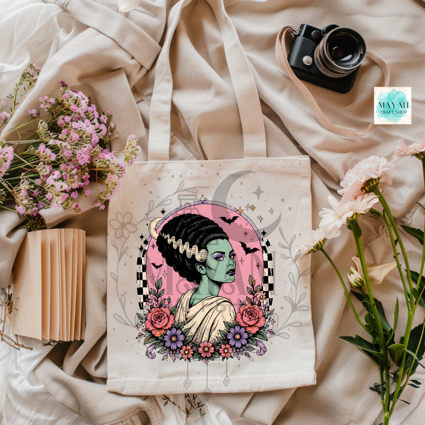 Tote bag with a colorful design of a woman with flowers and a camera on a soft fabric background