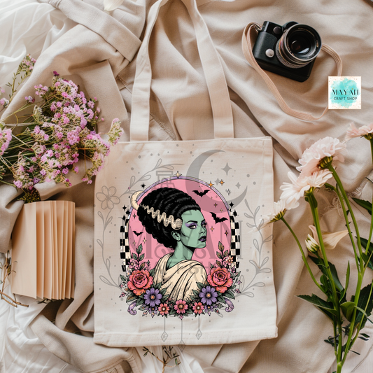 Tote bag with a colorful design of a woman with flowers and a camera on a soft fabric background