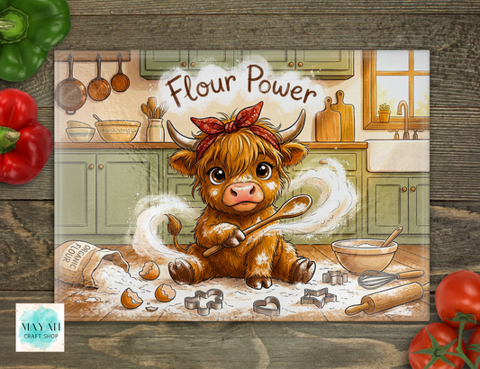 Cartoon cow in a kitchen with 'Flour Power' text, surrounded by kitchen items on a wooden surface.