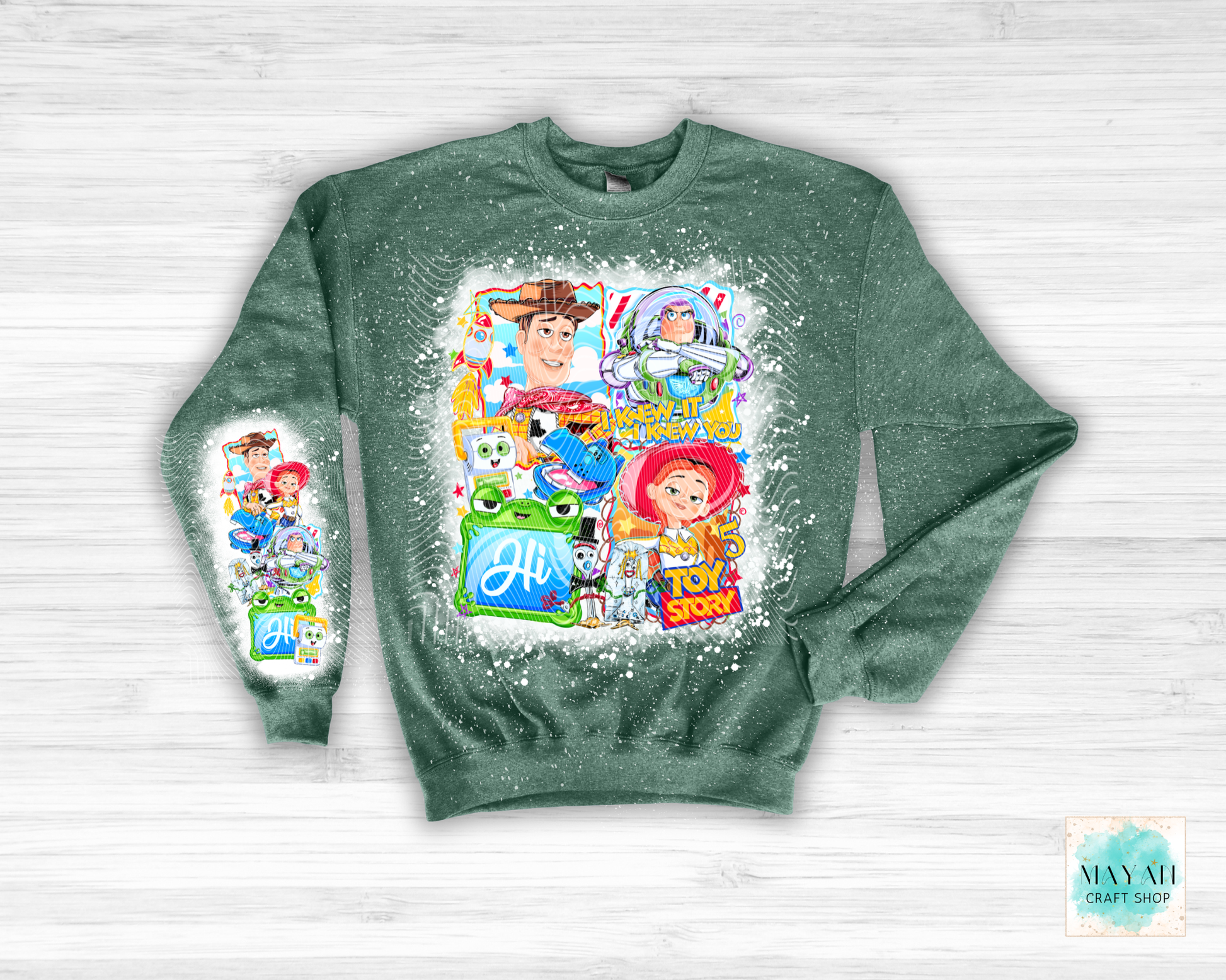 Green sweatshirt with character graphics on a white wooden background