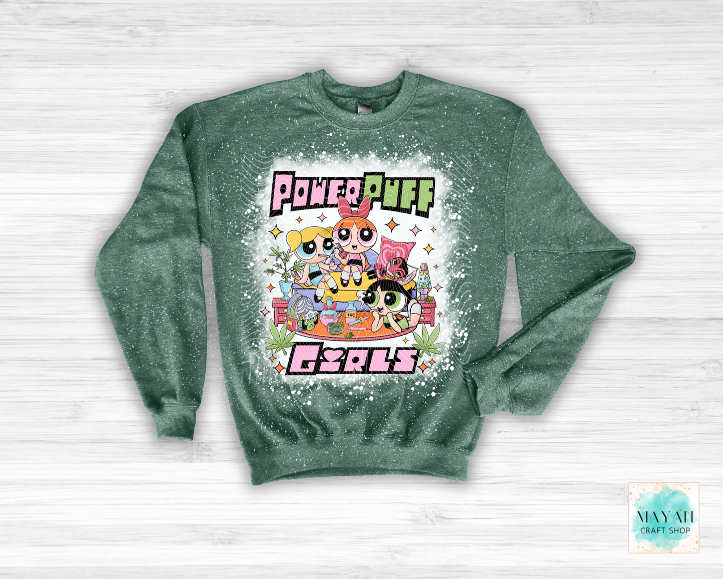 Green sweatshirt with vibrant graphic on a white wooden background