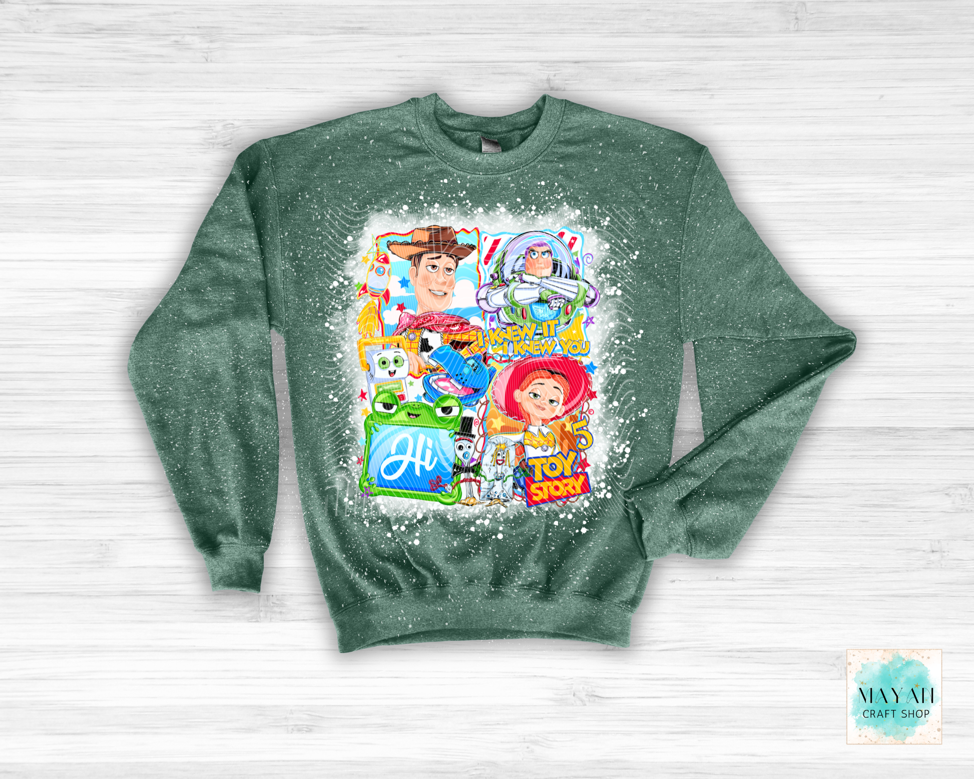 Green sweatshirt with character collage on a white wooden background
