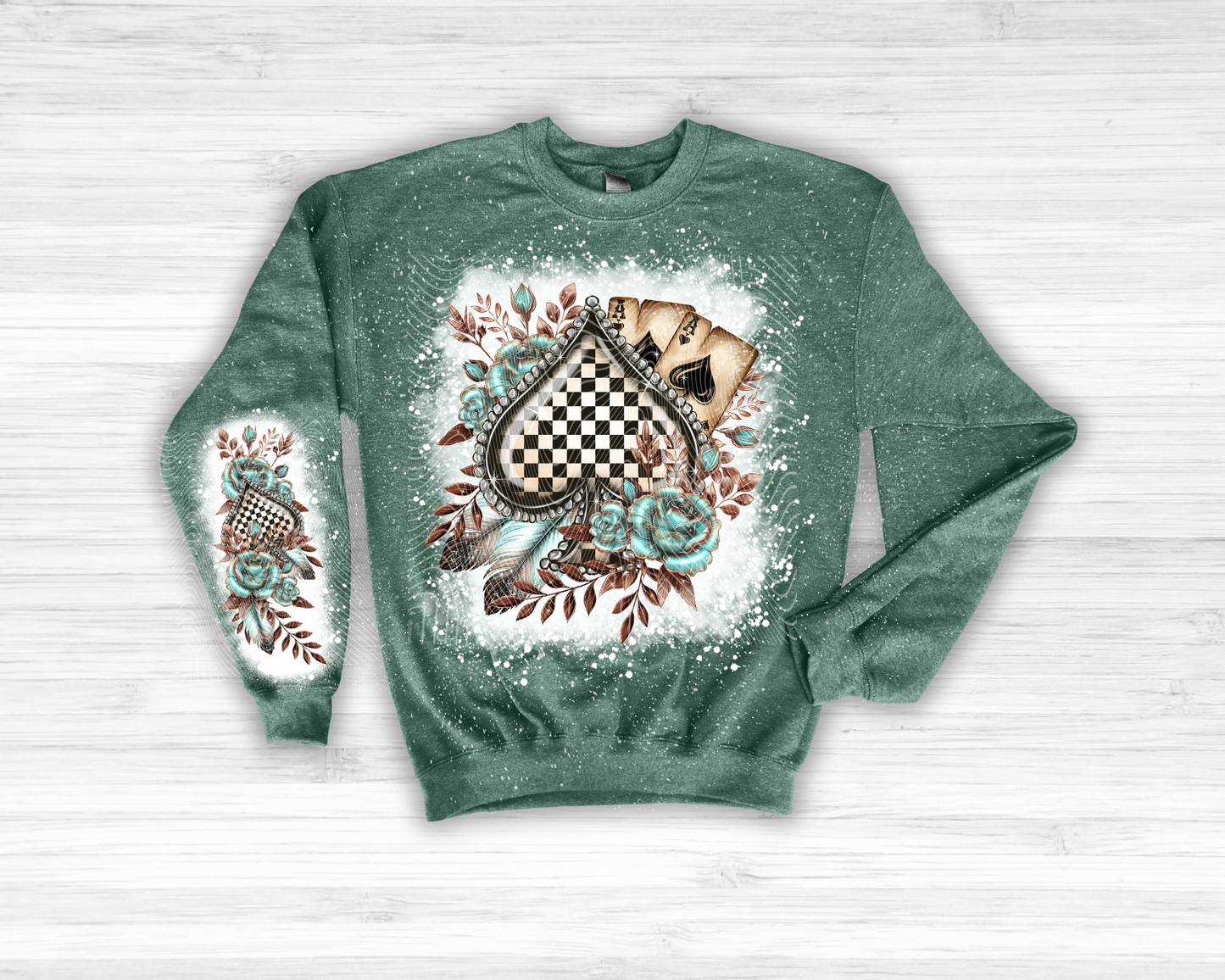 Green sweatshirt with decorative design on a white wooden background